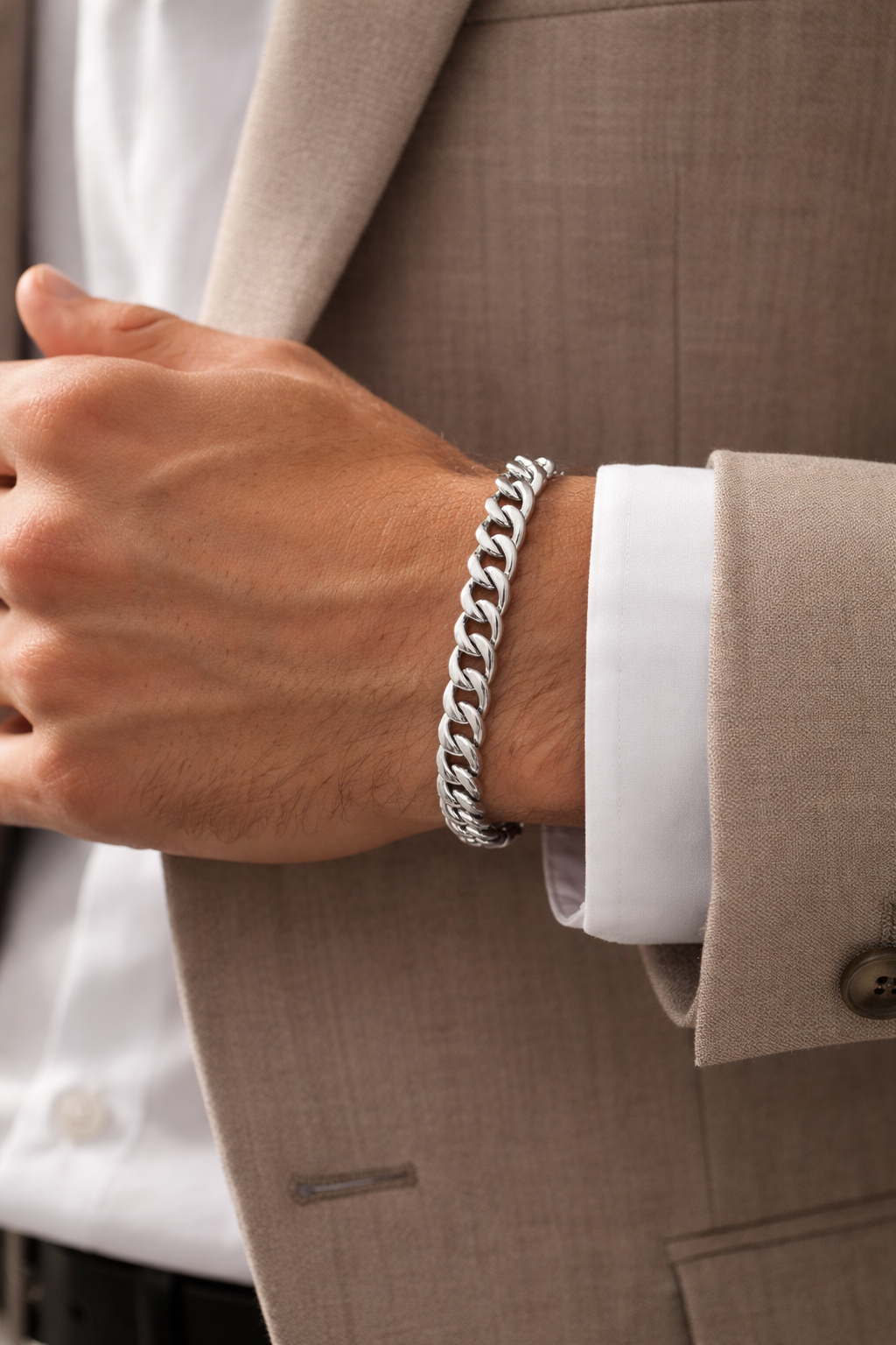 Hand wearing Teddy Howler hollow curb bracelet with a suit sleeve