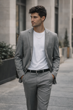 Man wearing Teddy Howler Franco chain necklace and a gray suit with a white shirt on a city street.