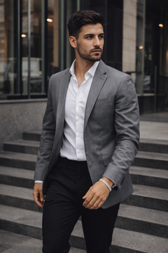 Man in a gray blazer and white shirt wearing a Teddy Howler Curb SF Pavé Bracelet standing on steps in an urban setting