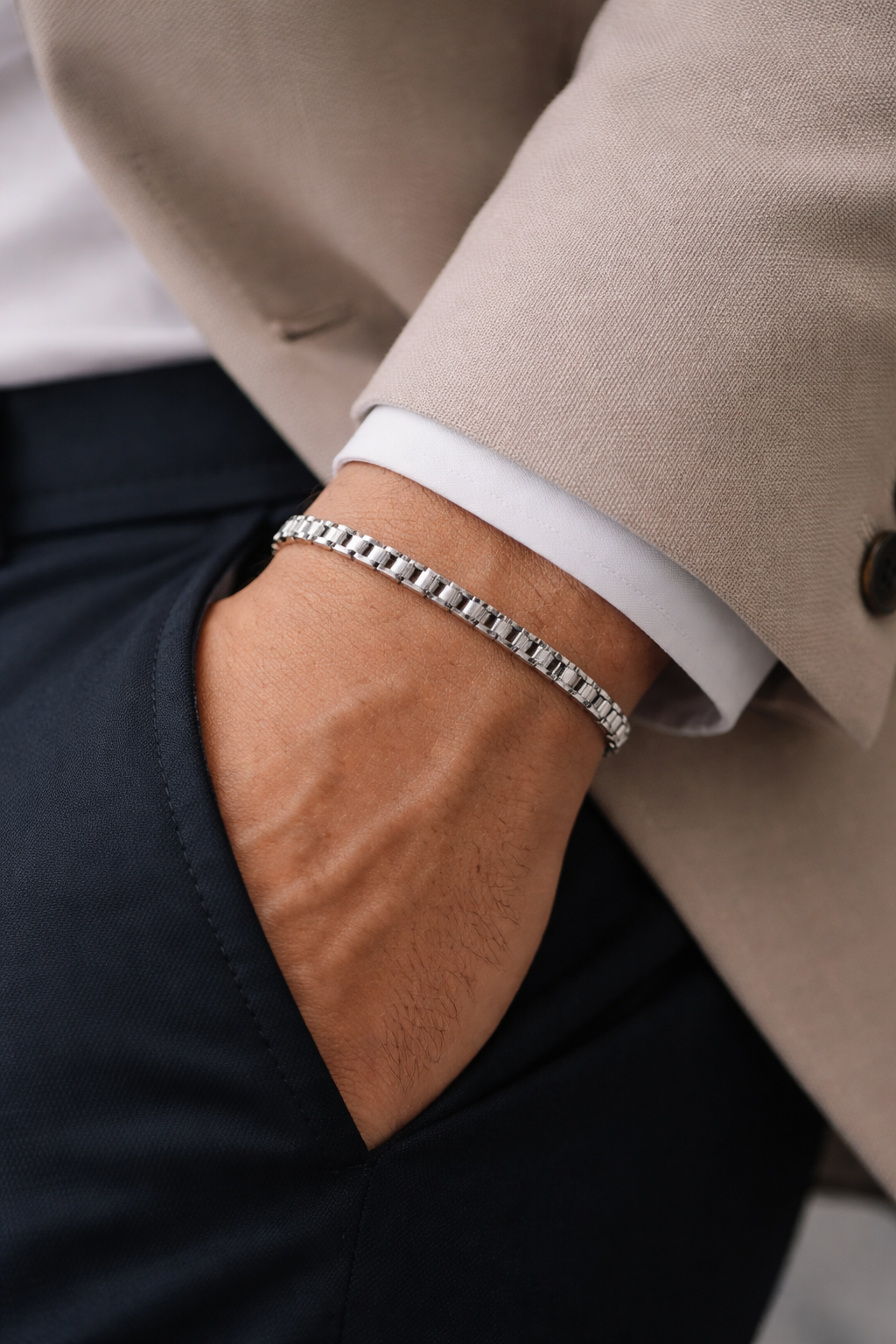 Close-up of a person wearing Teddy Howler Box chain bracelet on a wrist with a neutral background.