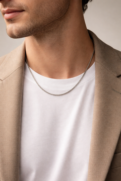 Man wearing Teddy Howler box chain necklace with a neutral background