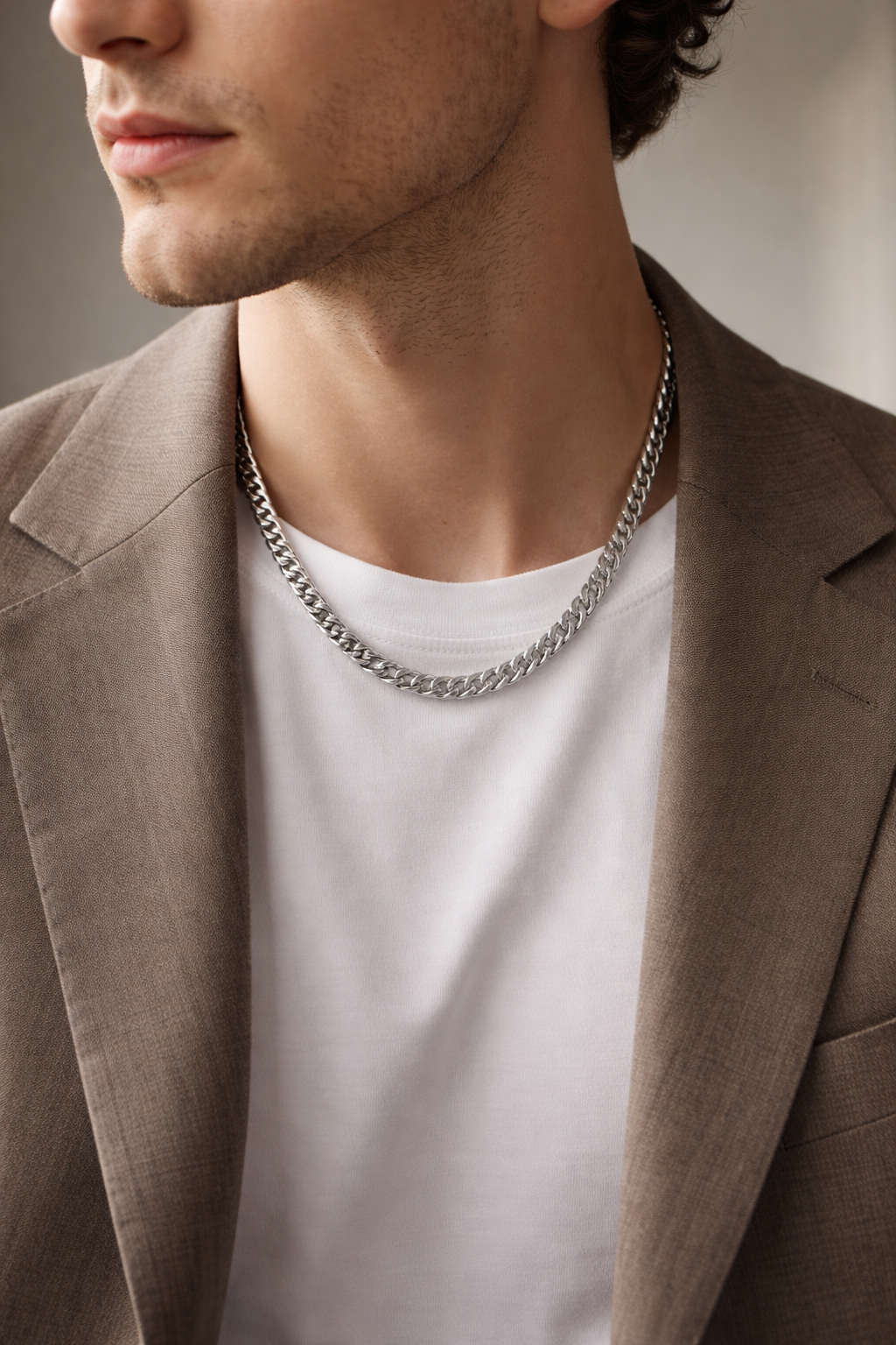 Man wearing a Teddy Howler Double link chain necklace with a neutral background