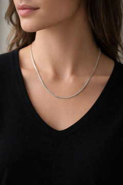 Woman wearing Teddy Howler box chain necklace worn by a person against a black background