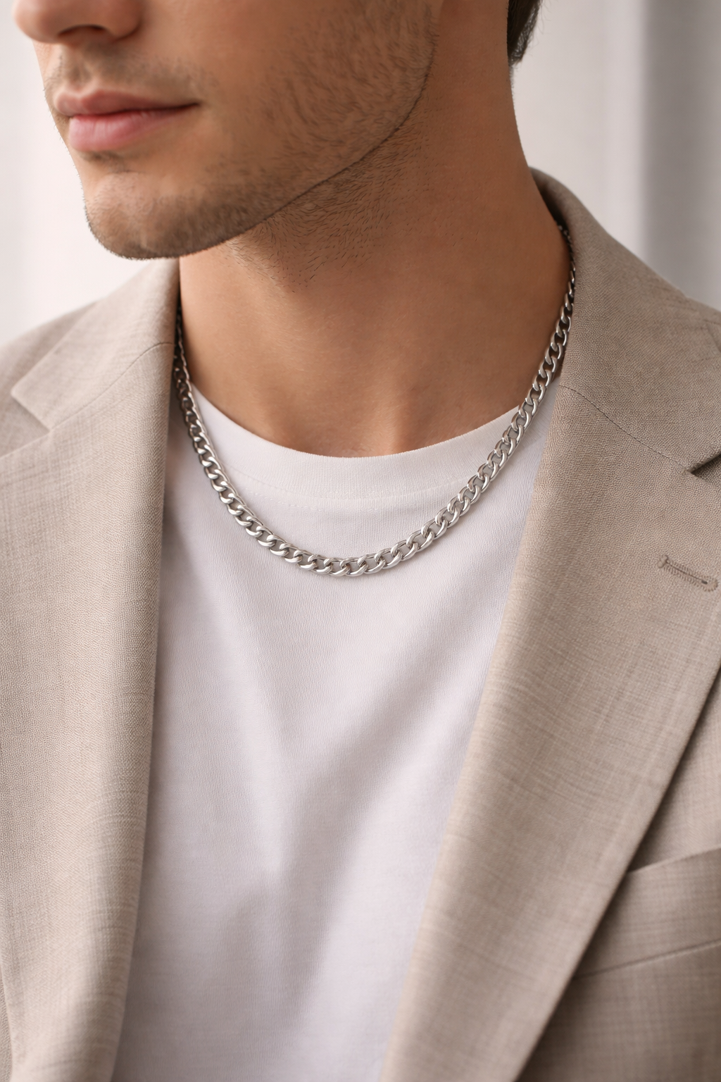 Man wearing a Teddy Howler hollow curb necklace with a neutral background