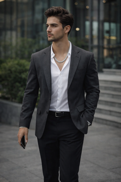 Man wearing a Teddy Howler Double link chain necklace in a suit walking outdoors with a blurred background