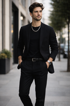 Man in a black suit wearing a Teddy Howler hollow curb necklace walking on a city street